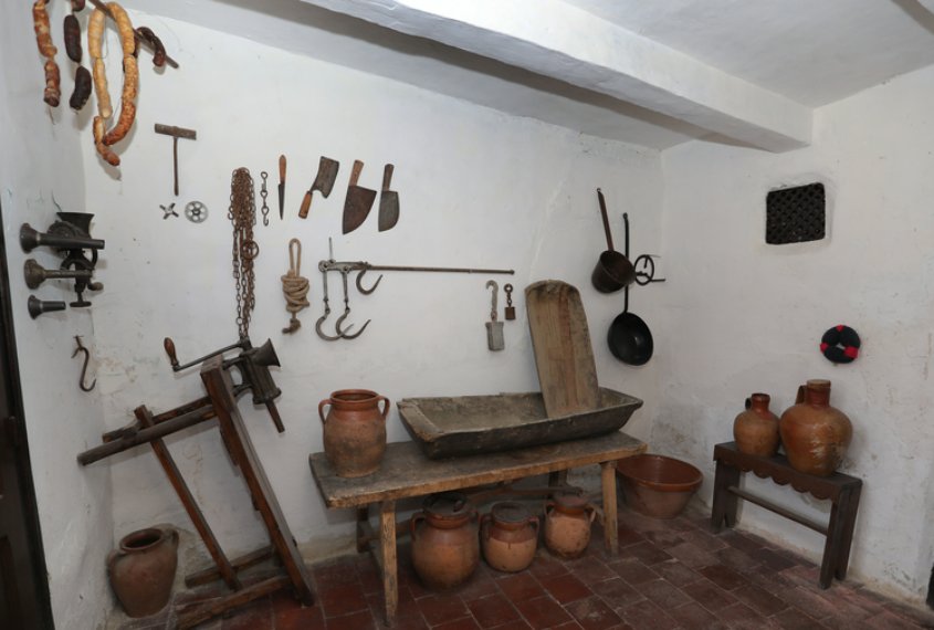 Interior de La Casa del Abuelo con utensilios antiguos y decoración rural