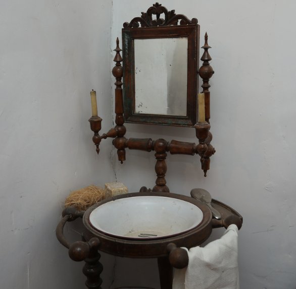 Antiguo lavabo de madera con espejo y candelabros en la Casa del Abuelo