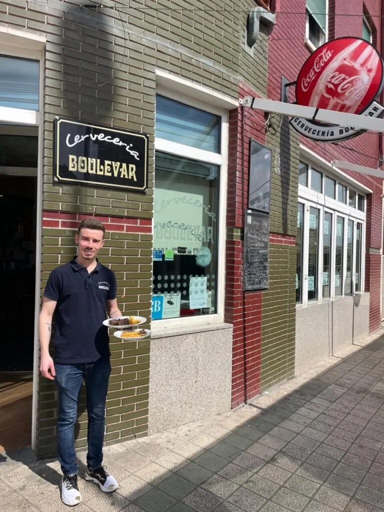Fachada de la Cervecería Boulevar con un camarero sosteniendo platos