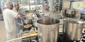 Cocineros preparando platos típicos en la cocina del Caupa