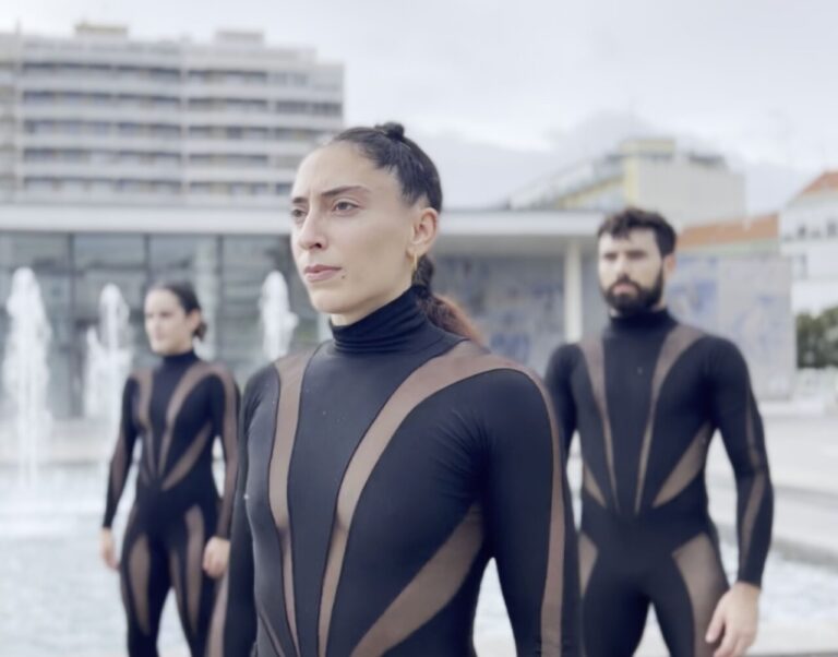 Actuación de Elvi Balboa en Danza a Escena con bailarines en trajes oscuros