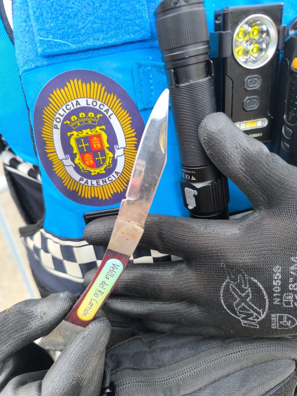Cuchillo y linterna en la mano de un policía local de Palencia