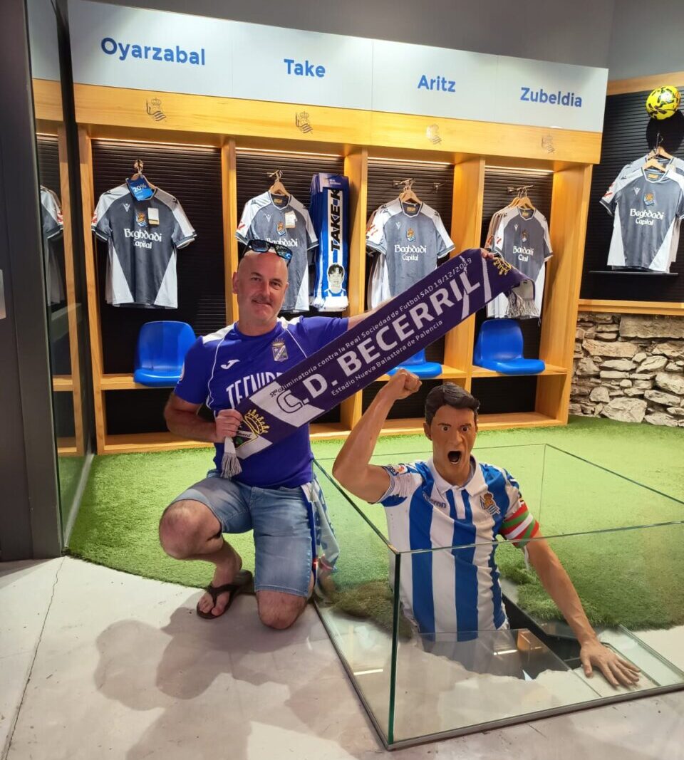 Aficionado sosteniendo bufanda del CD Becerril en un museo de fútbol