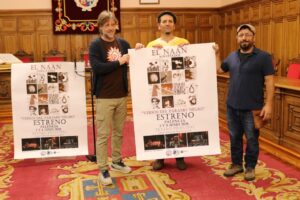 Tres hombres sosteniendo un cartel del estreno de El Naán en Palencia