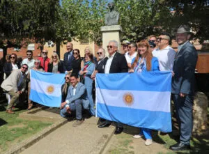 Grupo de personas con banderas argentinas en homenaje a San Martín
