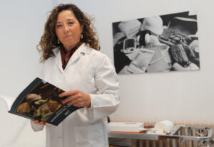 Profesional de enfermería sosteniendo un manual en un entorno clínico