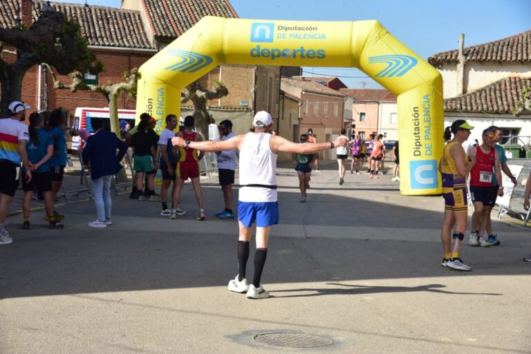 Corredores en la prueba Entre Castillos en Palencia bajo un arco de meta