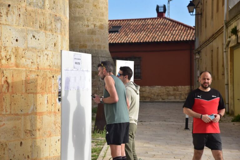 Corredores revisan la lista de inscripciones para la prueba Entre Castillos.