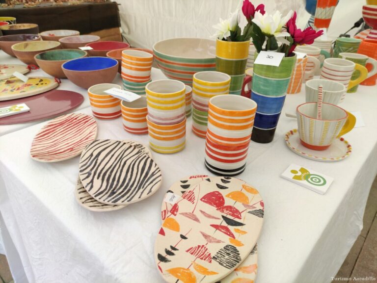 Mesa con cerámica colorida en la Feria de Cerámica de Astudillo