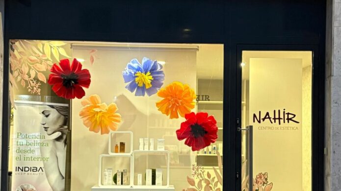 Fachada del centro de estética NAHIR en Guardo decorada con flores de papel