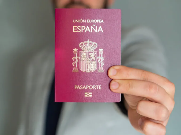 Hombre sosteniendo su pasaporte español de la Unión Europea