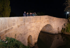 Grupo de personas en el puente del Canal de Castilla iluminado en Villaumbrales