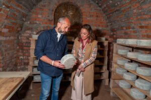 Dos personas observando un queso en una bodega tradicional de Palencia