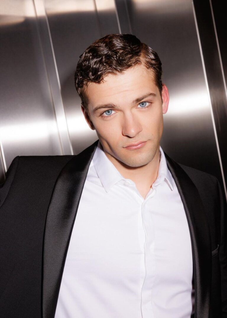 Jon Lukas, actor español, posando con traje elegante en un ascensor.