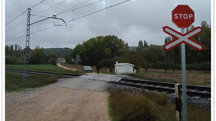 Paso a nivel en Alar del Rey con señalización de stop y vías de tren