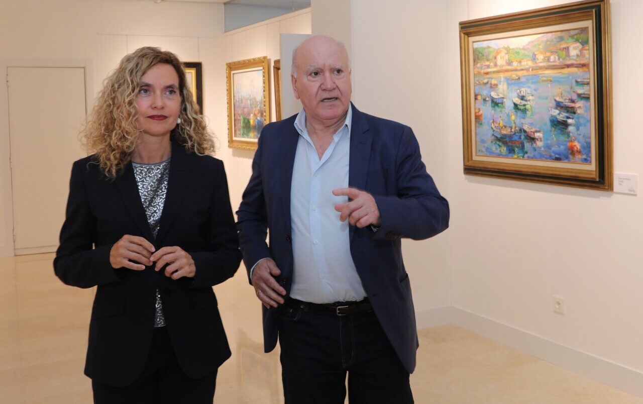 Meritxell Batet hablando en un auditorio con obras de arte al fondo