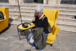 Mujer hablando por teléfono en un entorno cultural con sillones amarillos