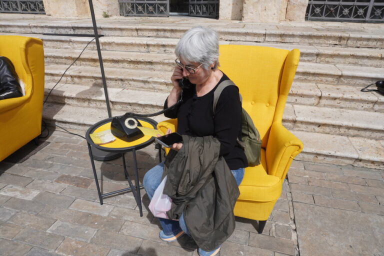 Mujer hablando por teléfono en un entorno cultural con sillones amarillos