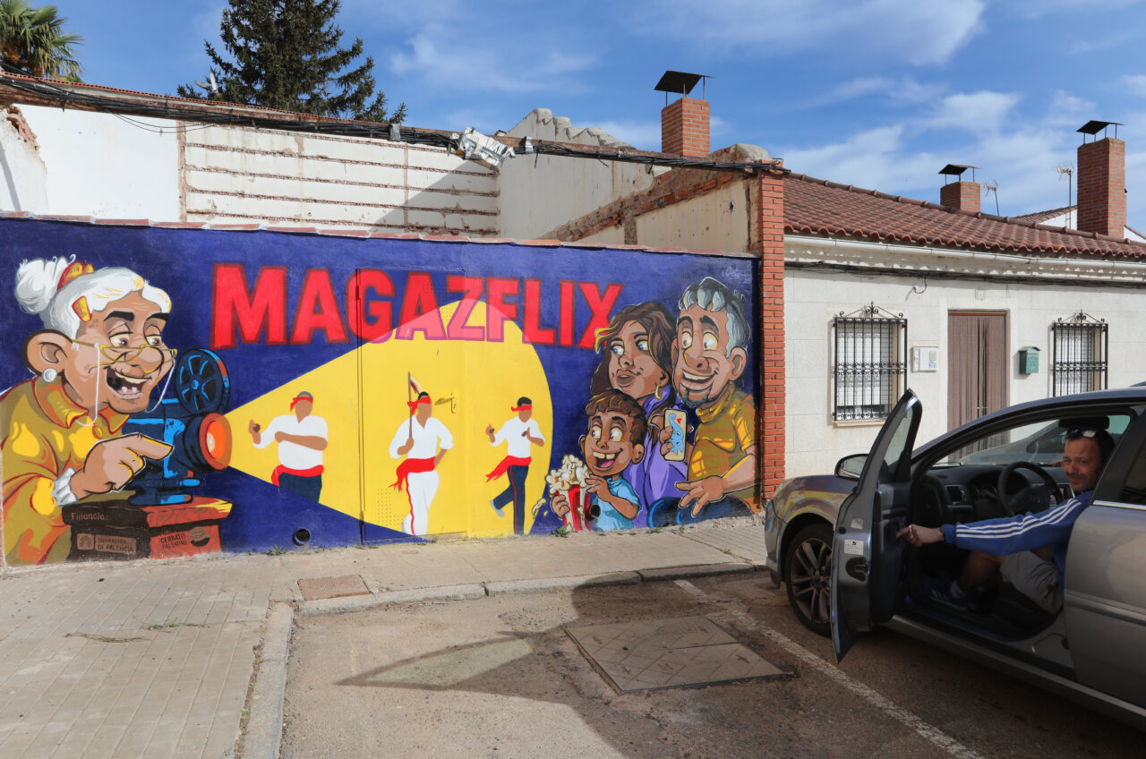 Mural colorido que representa a una abuela y niños disfrutando del cine