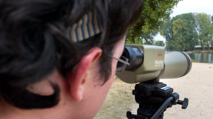 Persona observando aves con un telescopio en el Canal de Castilla
