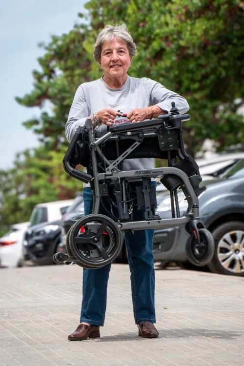 Mujer mayor sosteniendo un andador en la calle