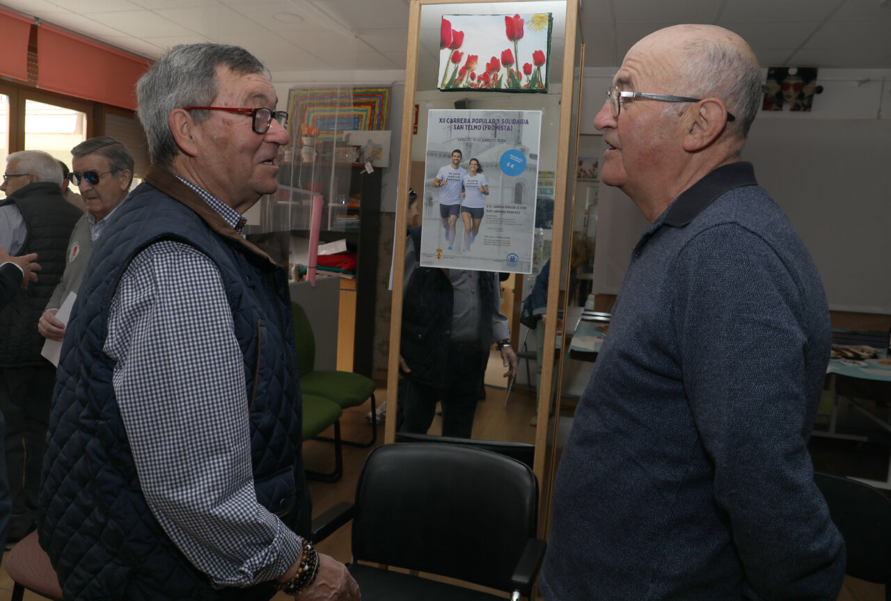 Dos hombres conversando en un evento sobre el Párkinson en Palencia.