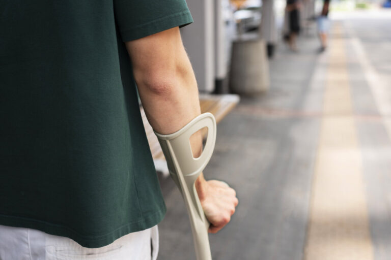 Persona con muletas caminando por la ciudad en un día soleado