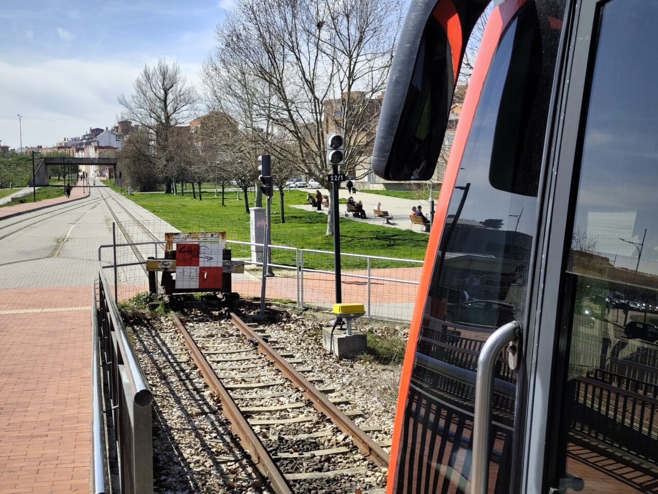 Tren en la plataforma de Feve en León con paisaje urbano al fondo