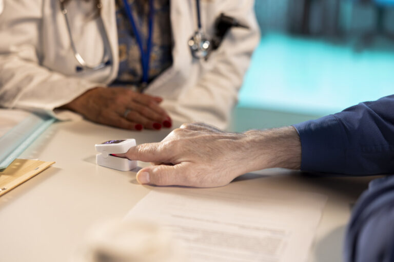 Médico usando un oxímetro para medir niveles de oxígeno en un paciente