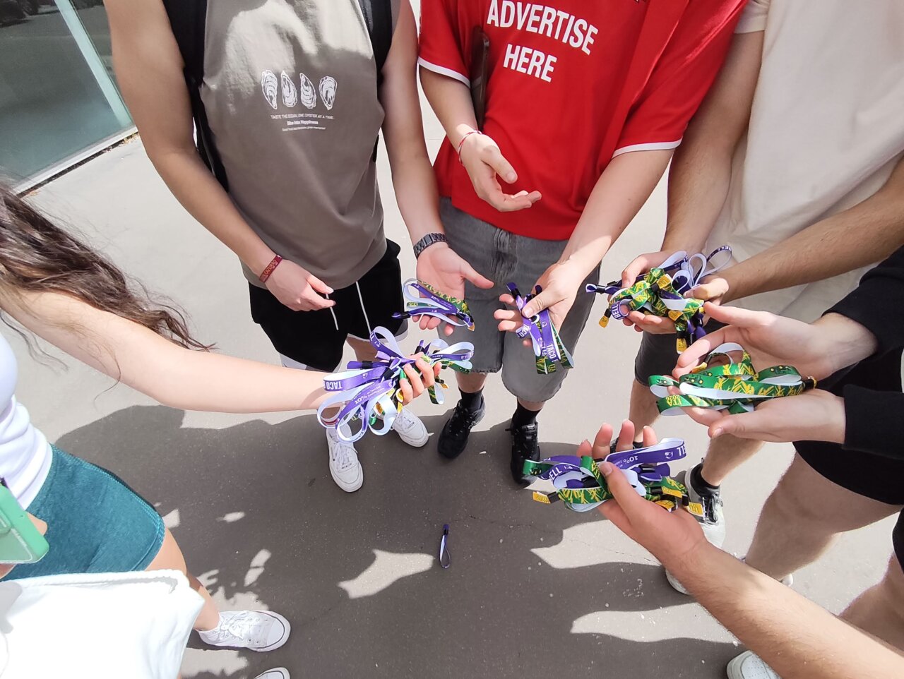 Grupo de personas mostrando pulseras de acceso a un evento