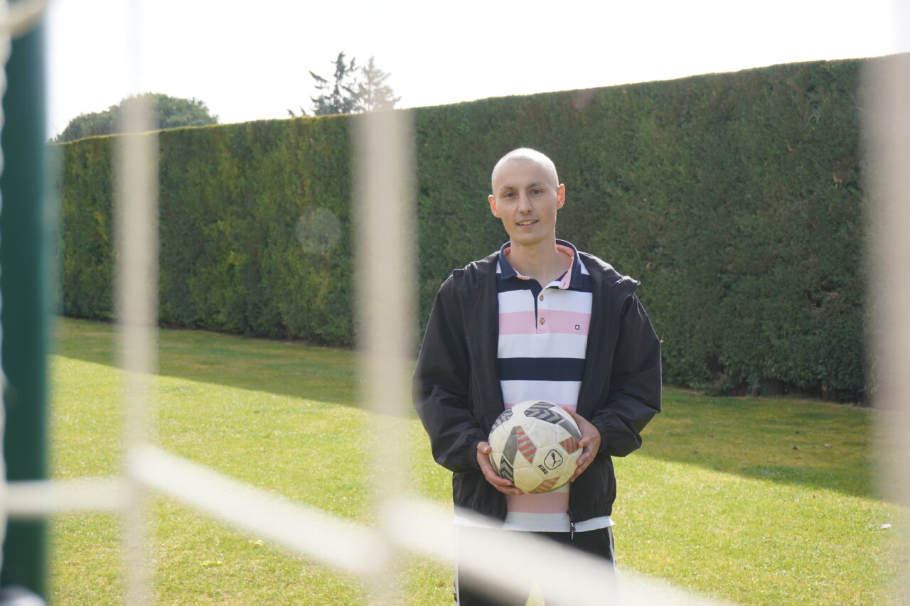 Mario Martínez, jugador de fútbol, sosteniendo un balón en el campo.