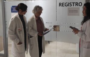 Tres profesionales de la salud revisando documentos en una oficina.