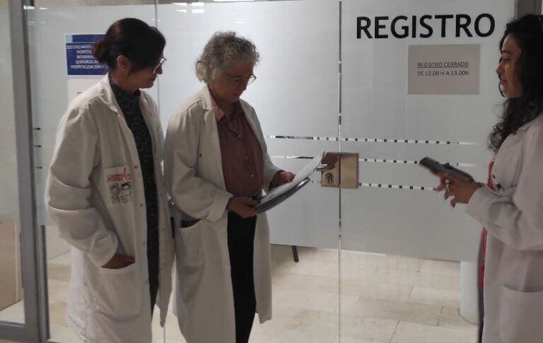 Tres profesionales de la salud revisando documentos en una oficina.