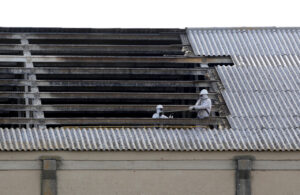 Trabajadores en la retirada de cubiertas de amianto en una construcción