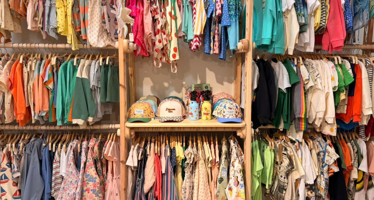 Estante con ropa infantil variada en la tienda Pirrakas Kids