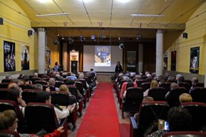 Auditorio lleno durante la Semana de Cine en Saldaña con cartelera visible