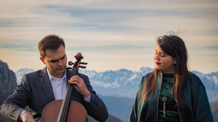 Músicos de Terra Sigilata en un paisaje montañoso tocando instrumentos musicales.