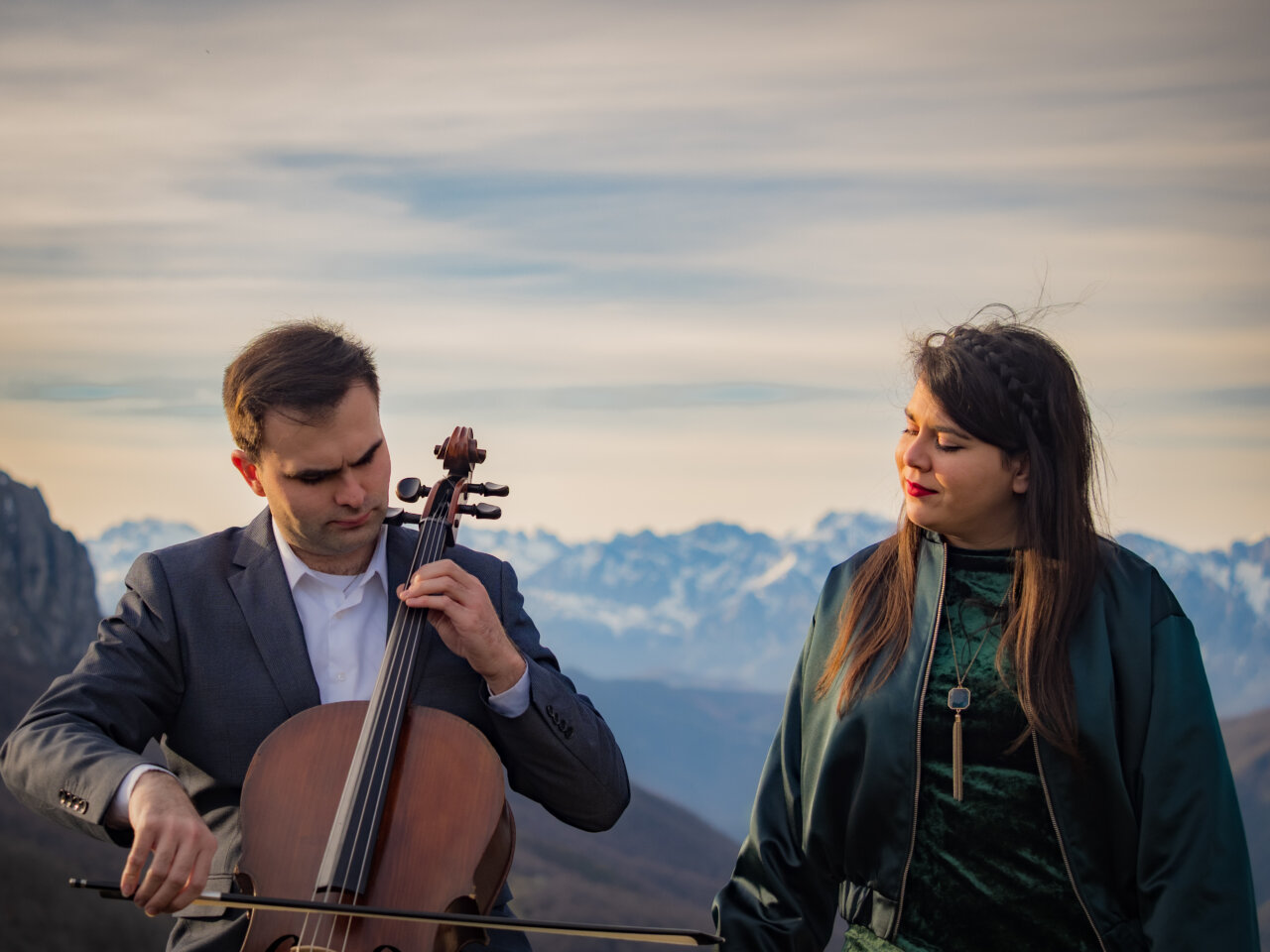 Músicos de Terra Sigilata en un paisaje montañoso tocando instrumentos musicales.