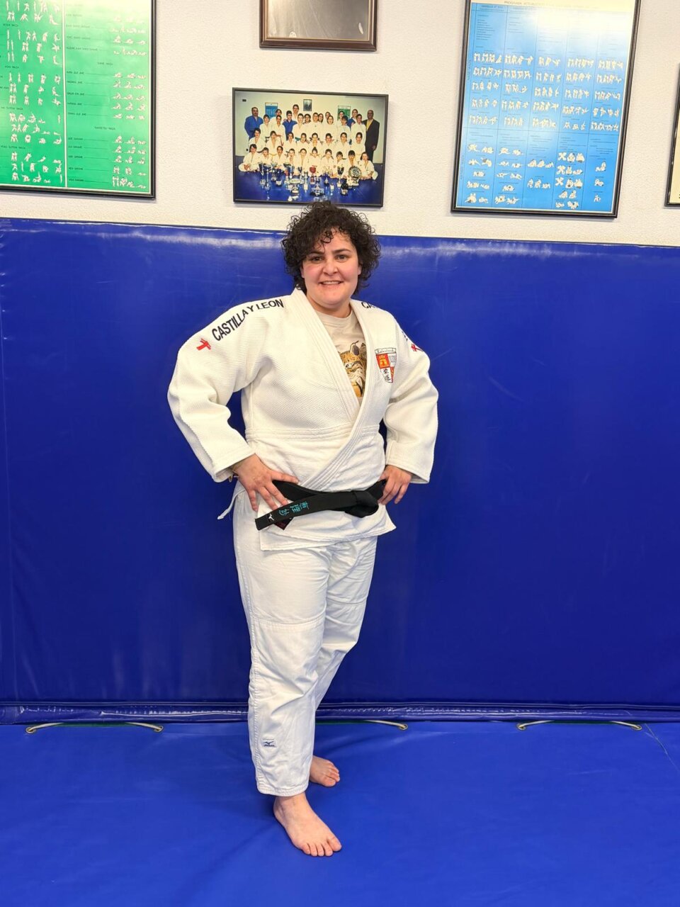 Judoca posando en el tatami con un cinturón negro y un gi blanco