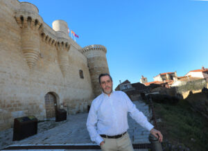 Hombre frente al castillo de Fuentes de Valdepero con cielo azul
