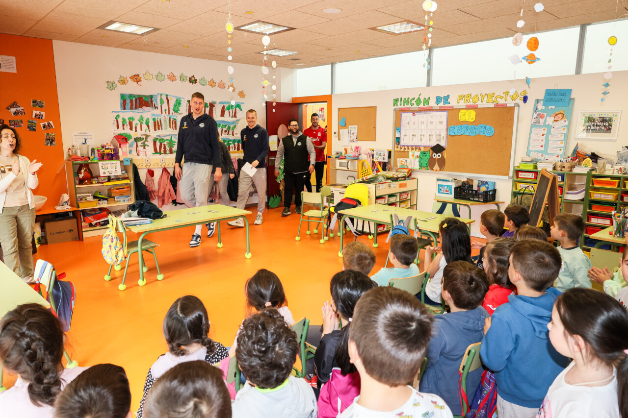 Grupo de niños en aula infantil con visitantes