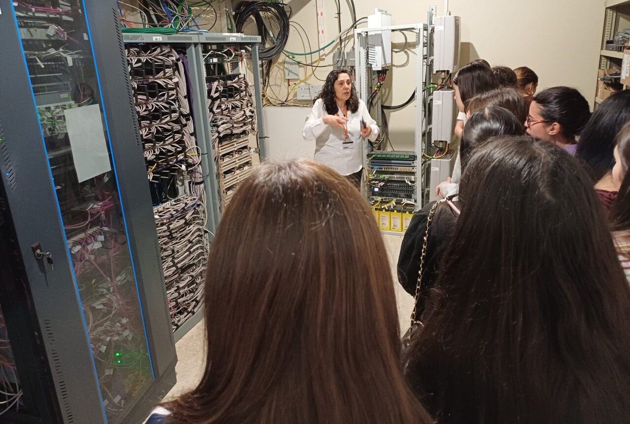 Estudiantes observan a una profesional explicando tecnología en el hospital