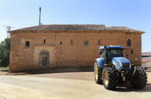 Iglesia de San Pedro de Villalcázar de Sirga con tractor en primer plano