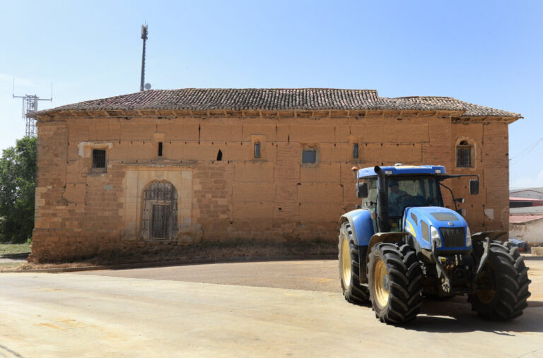 Iglesia de San Pedro de Villalcázar de Sirga con tractor en primer plano