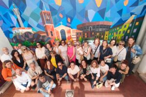 Grupo de personas frente a un mural en San Juanillo