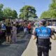Agente de policía supervisando un mercadillo en Palencia con vendedores y compradores.