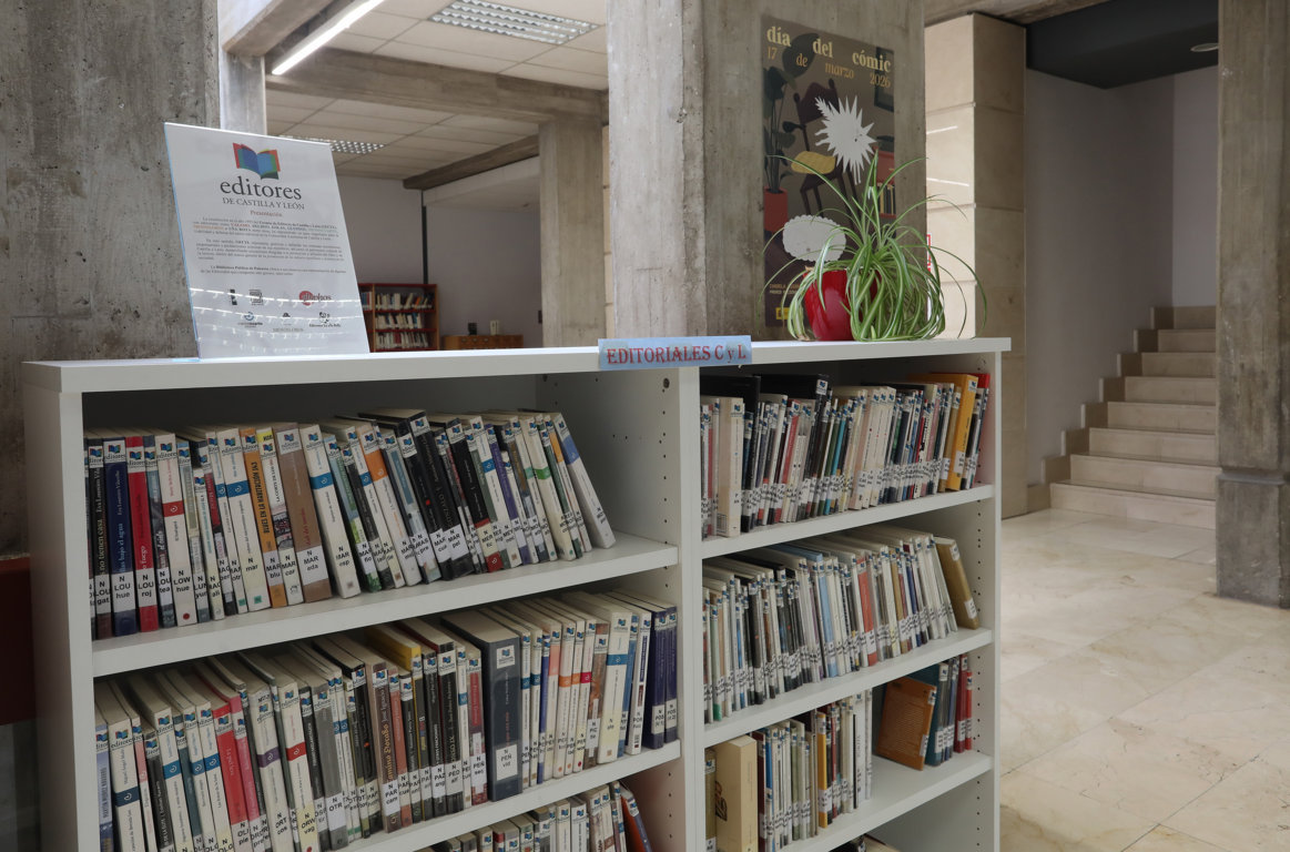 Estantería de libros en la Biblioteca Pública de Palencia con un cartel informativo.