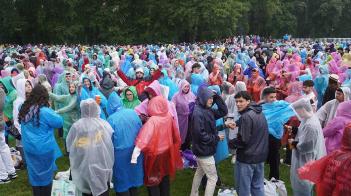 Multitud de jóvenes con chubasqueros de colores en un evento al aire libre