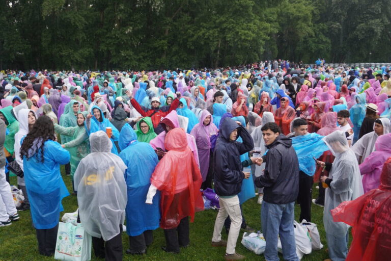 Multitud de jóvenes con chubasqueros de colores en un evento al aire libre
