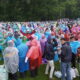 Multitud de jóvenes con chubasqueros de colores en un evento al aire libre
